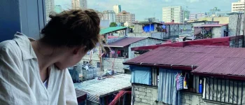 Natalie schaut aus dem Fenster auf einen Slum von Manilla