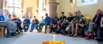 Menschen sitzen in einer Kapelle und singen