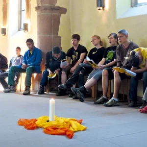 Menschen sitzen in einer Kapelle und singen