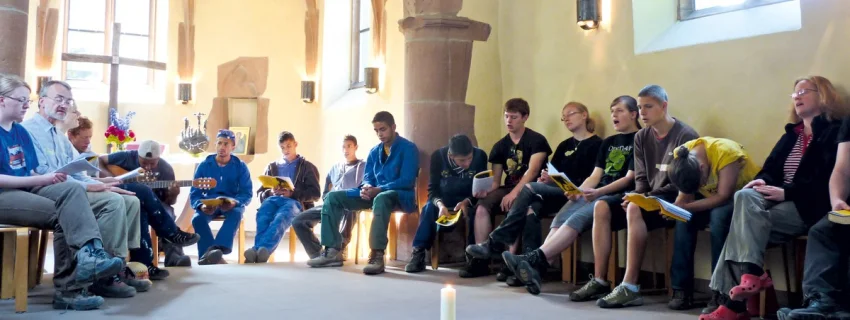 Menschen sitzen in einer Kapelle und singen